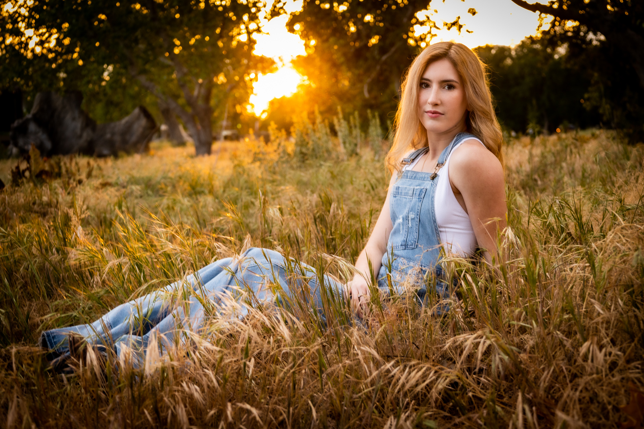 girl sitting in front of sunset in red bluff ca