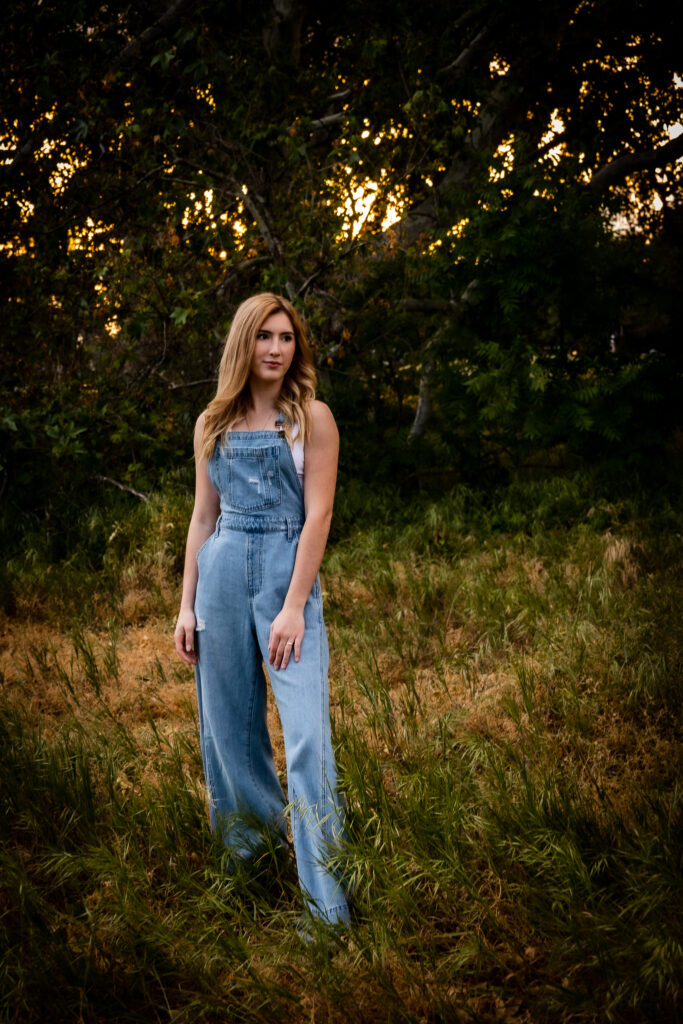 girl standing in green forest during senior session in red bluff ca