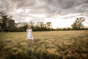 girl standing in field during her senior session