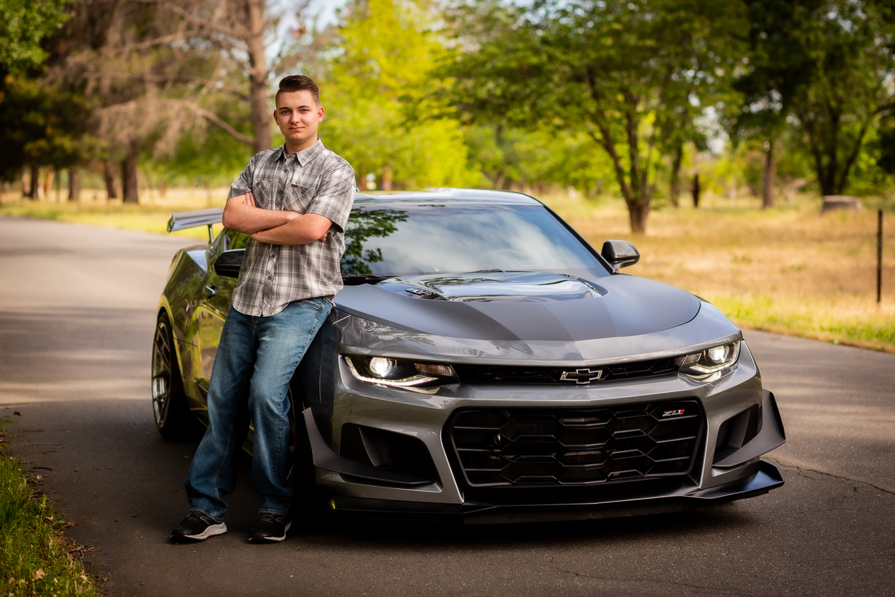 RED BLUFF CA SENIOR STANDING IN FRONT OF CAMARO