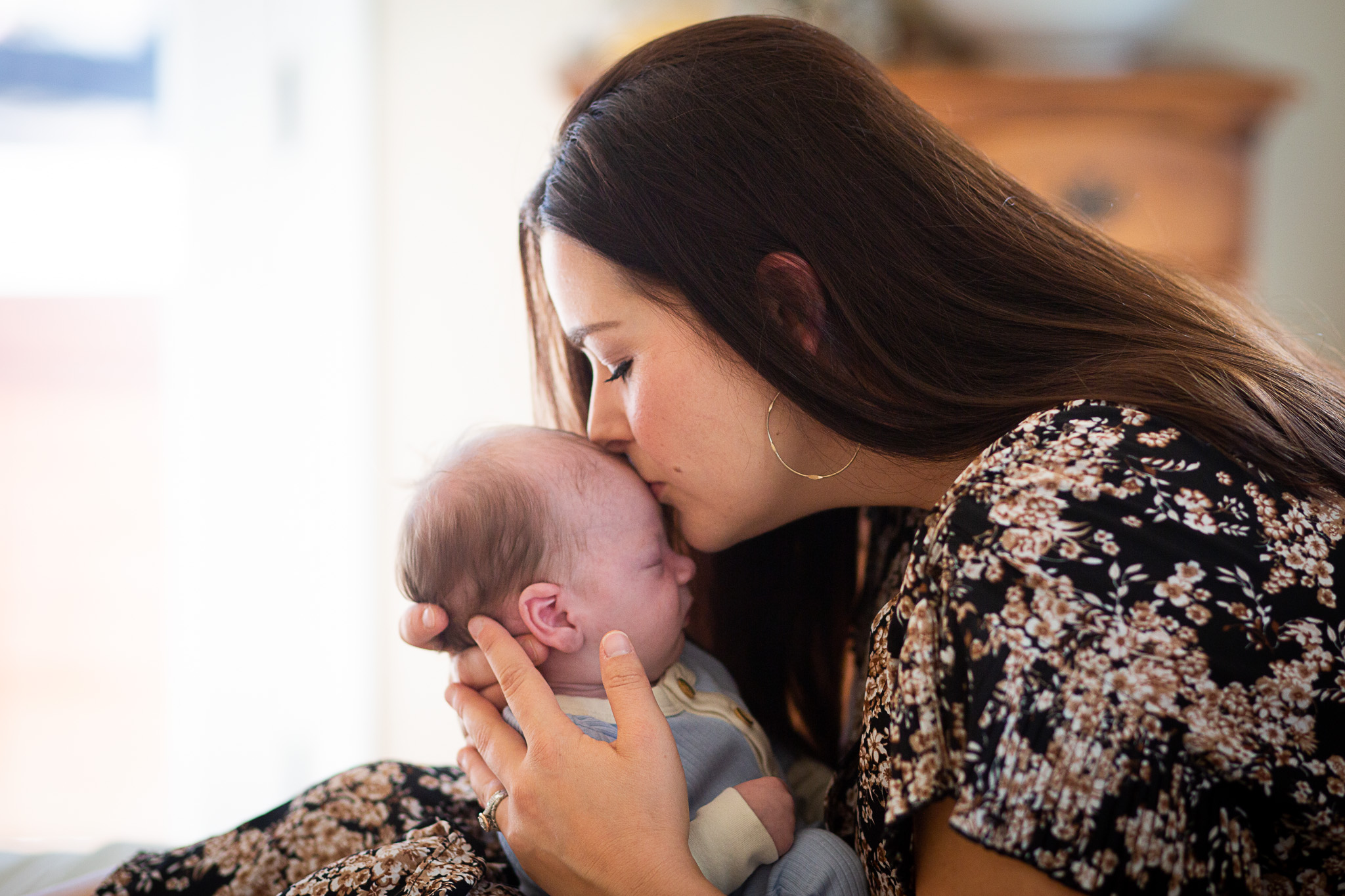 mom kissing newborn son
