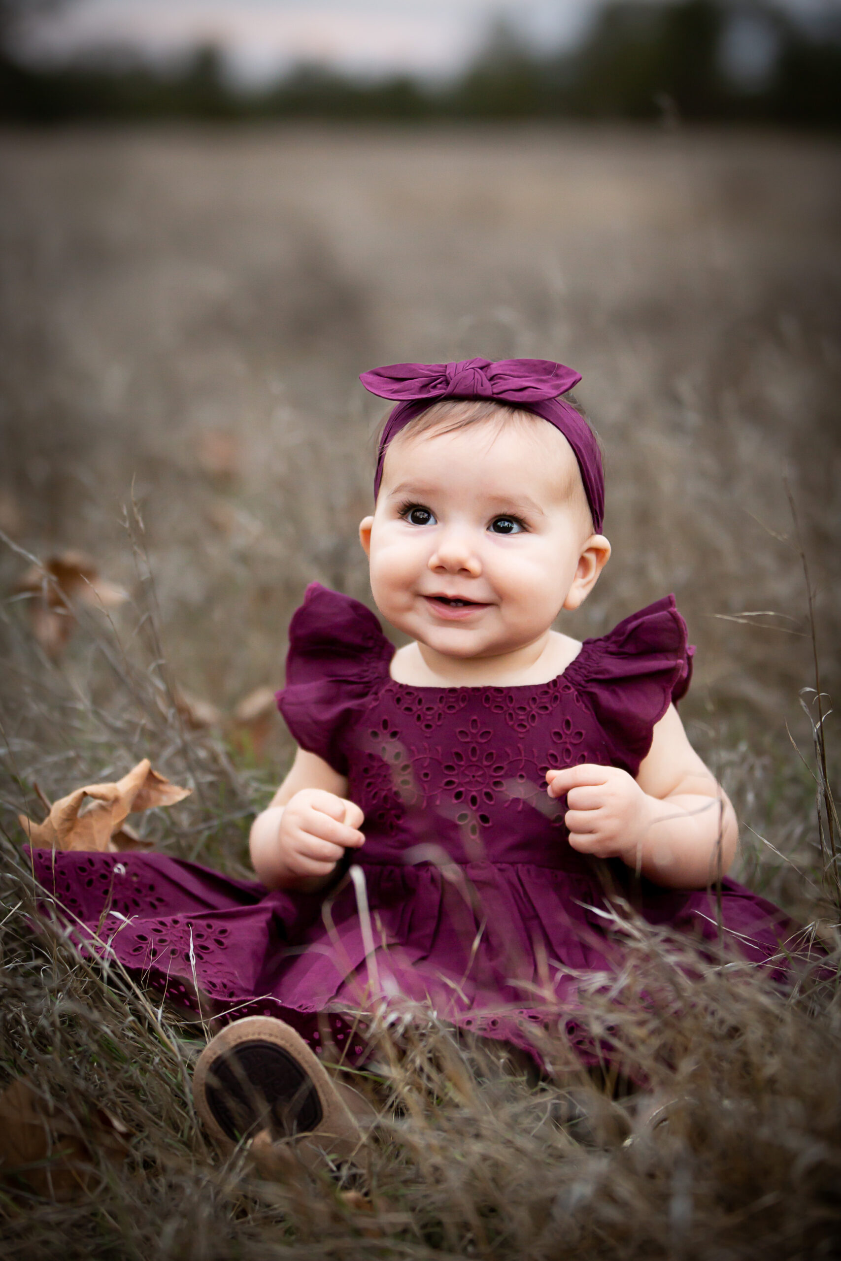 toddler sitting in open field