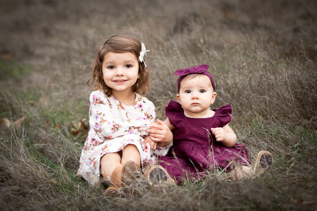 two girls sitting in grass
