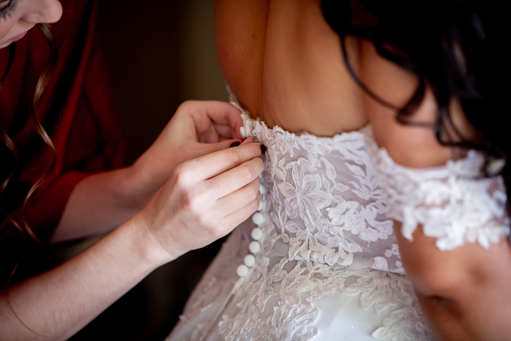 back of brides dress getting buttoned up