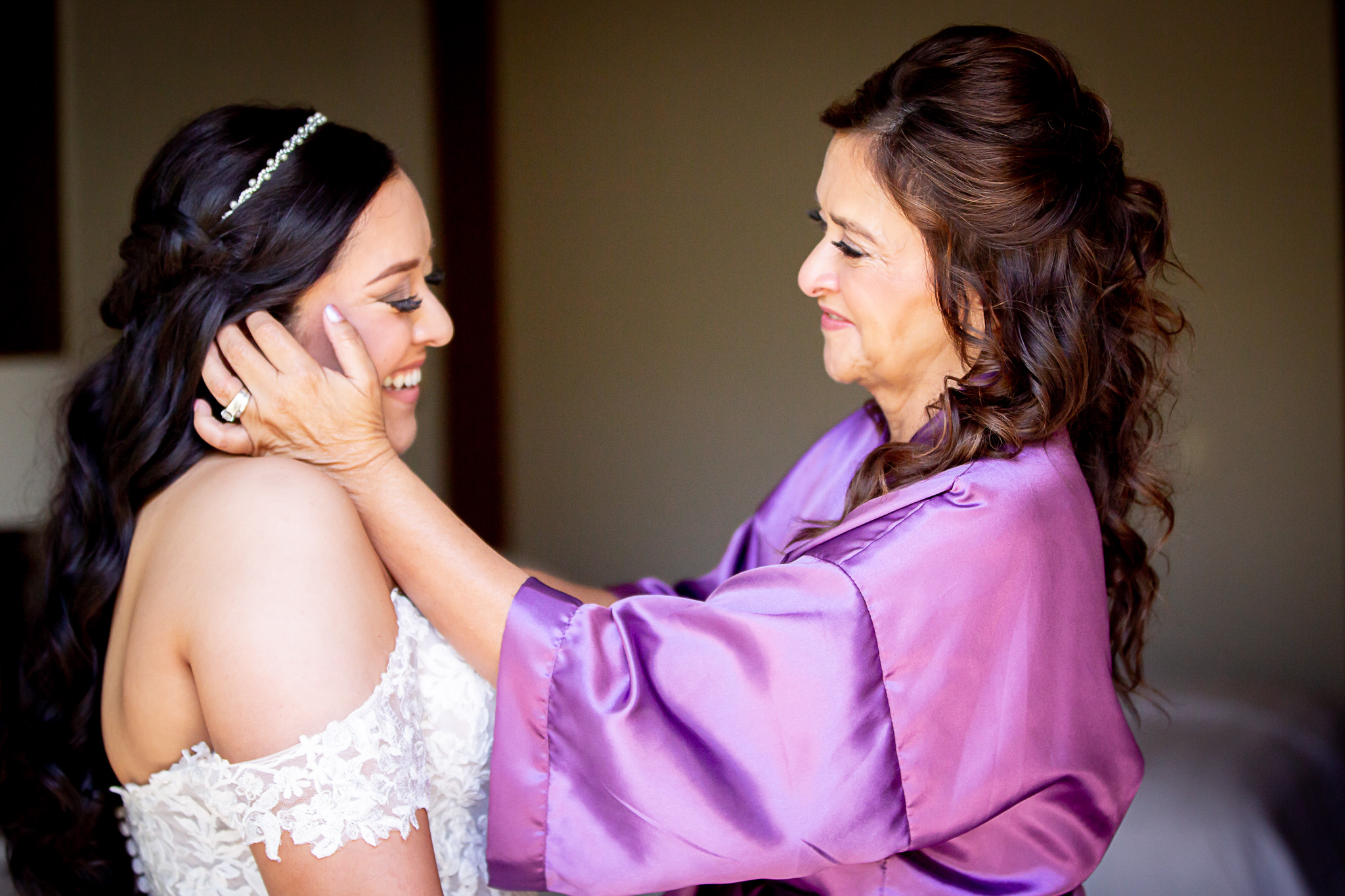 mom getting daughter ready in wedding dress