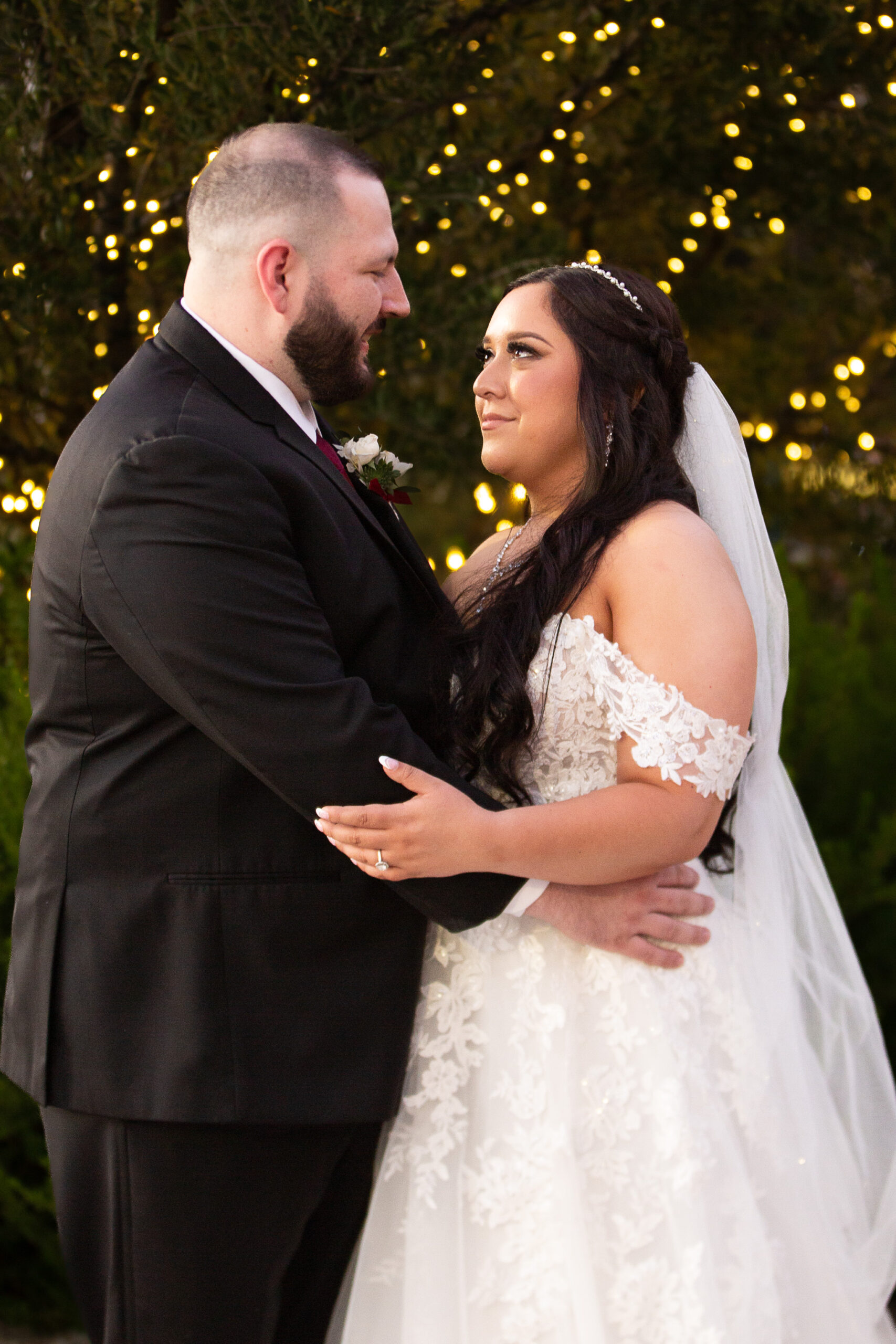 bride and groom in front of twinkle lights