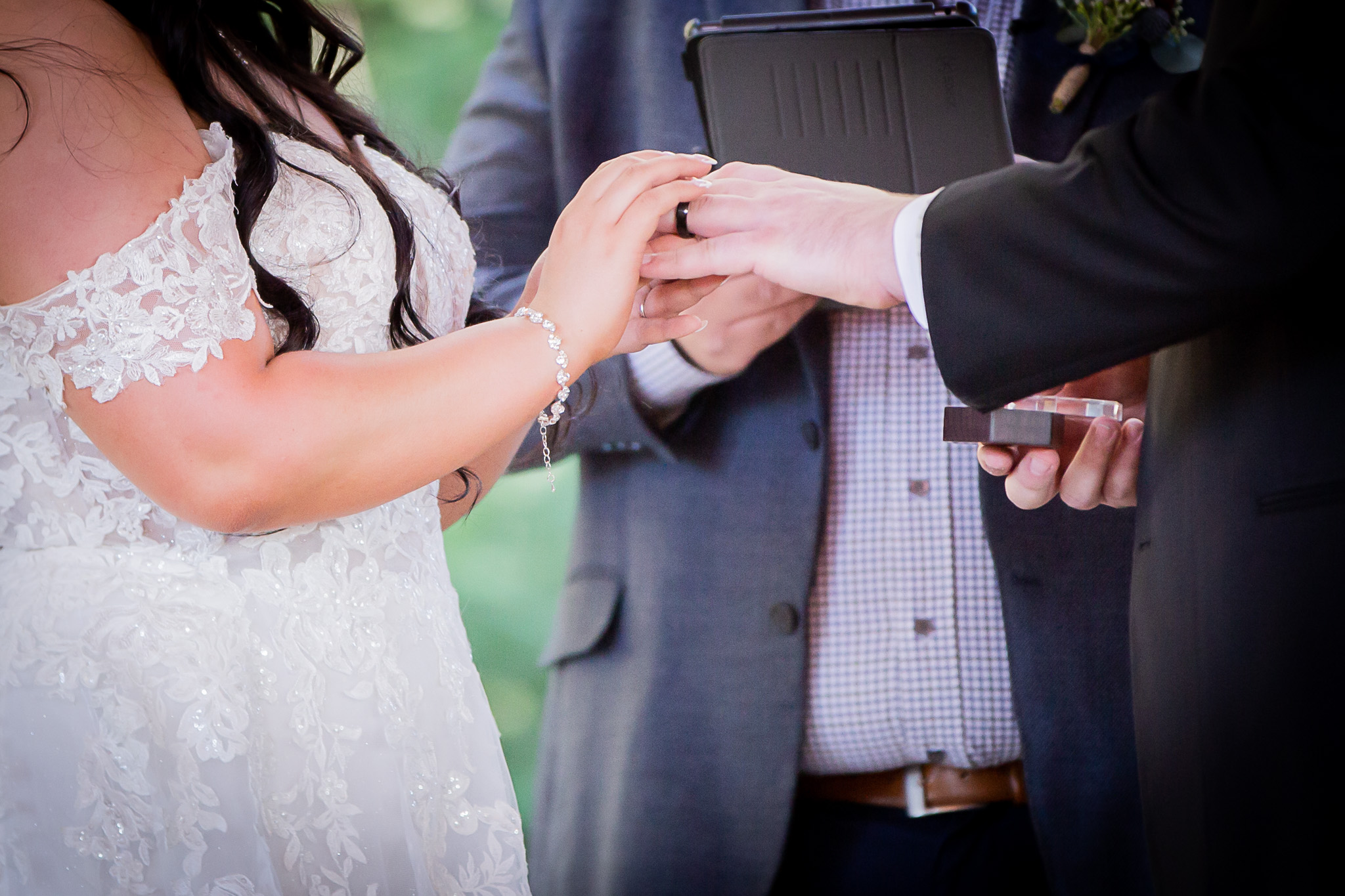 bride putting on grooms ring