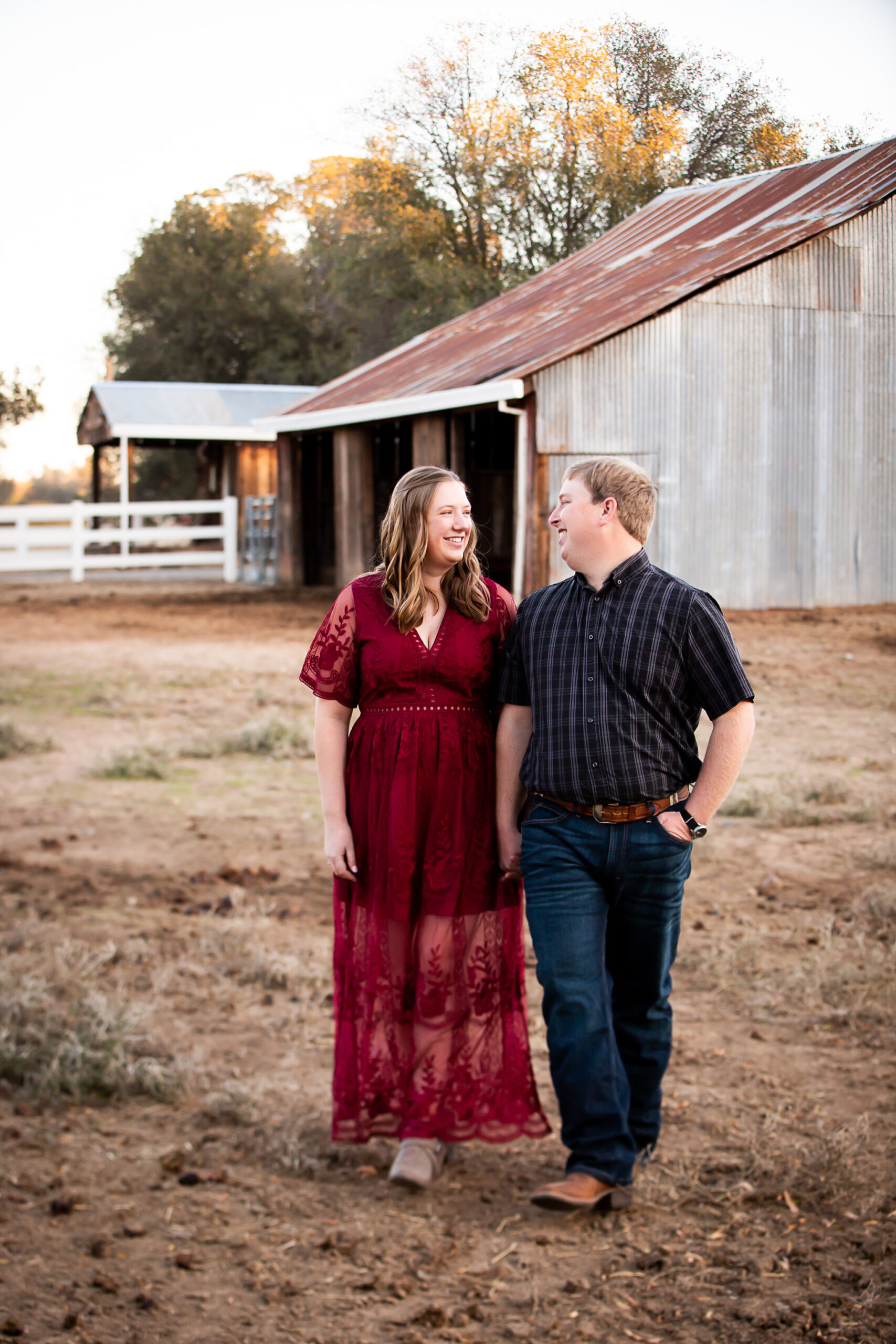 couple standing in front of barn during maternity session