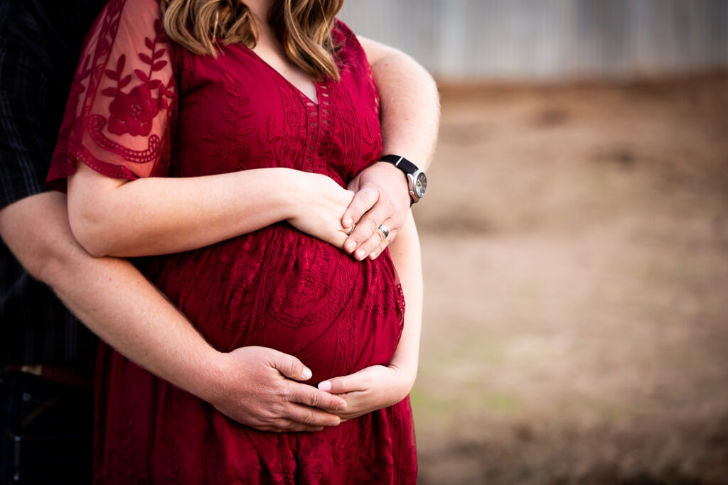 hands holding pregnant belly