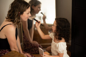 daughter putting makeup on mom