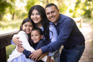 family of four huddling on bridge