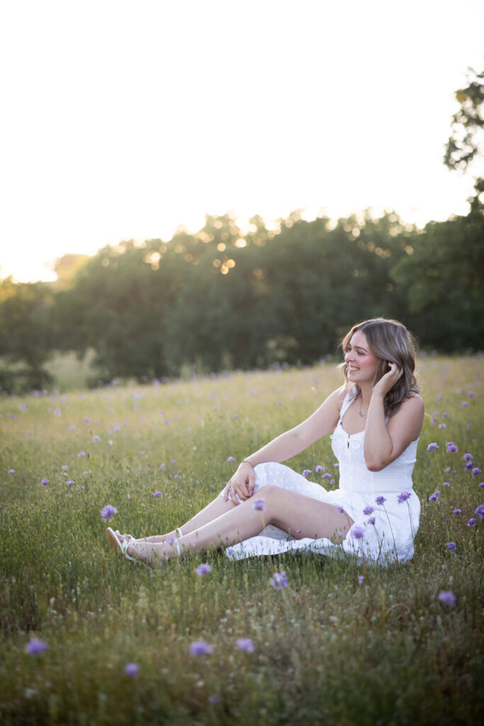 girl in white dress sitting in purple flowers in red bluff ca