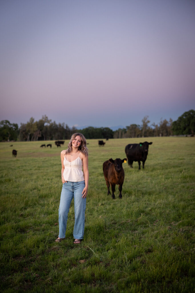 girl standing in field with Angus cattle in red bluff ca