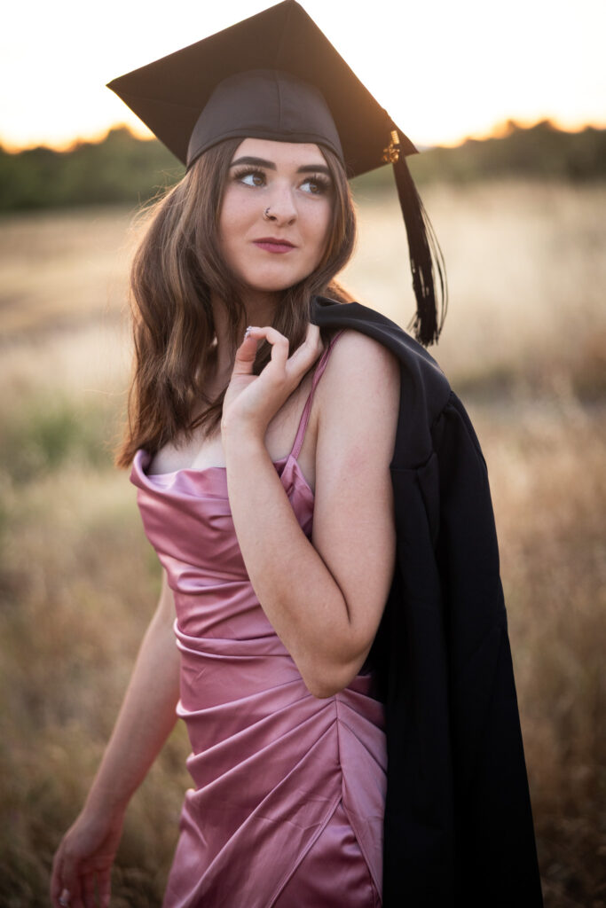 girl in graduation cap with gown over shoulder