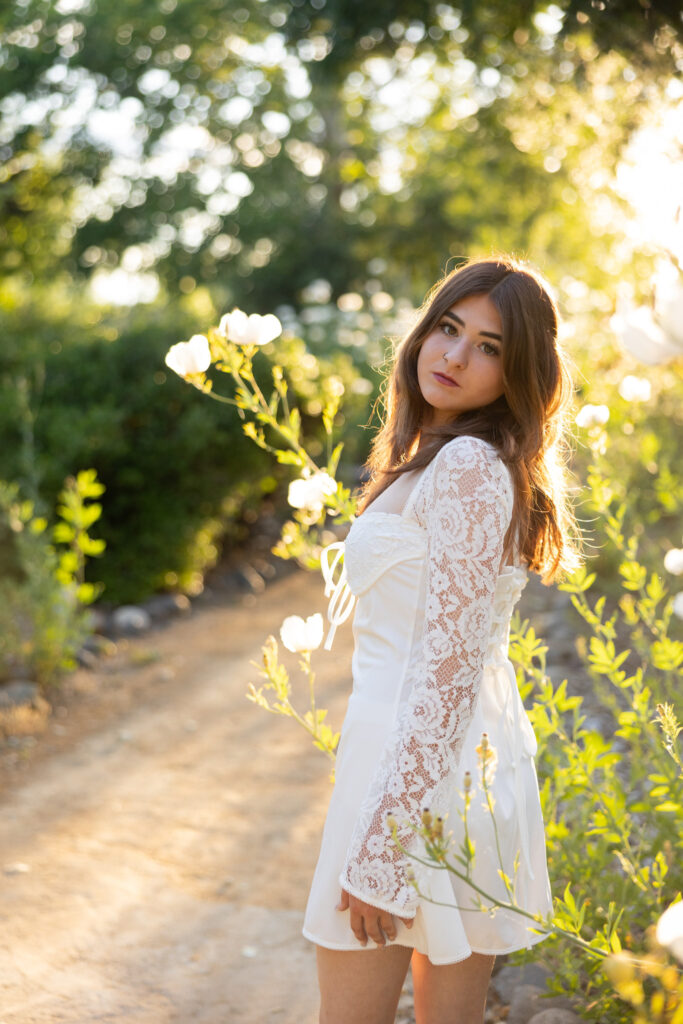 girl looking over her shoulder in a golden hour garden