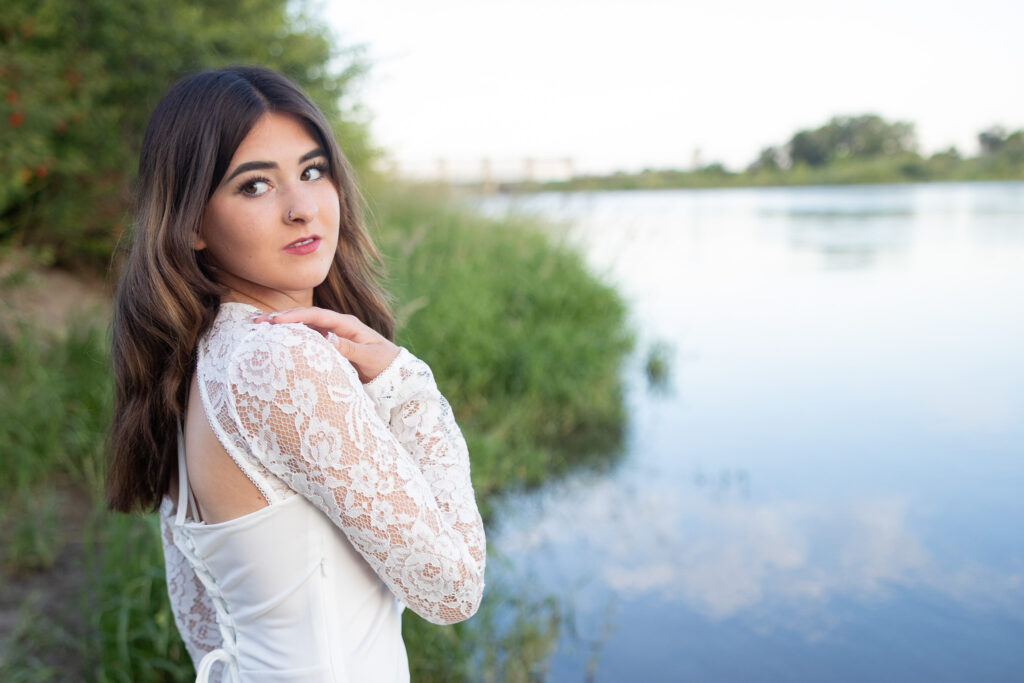 girl standing by water looking over her shoulder
