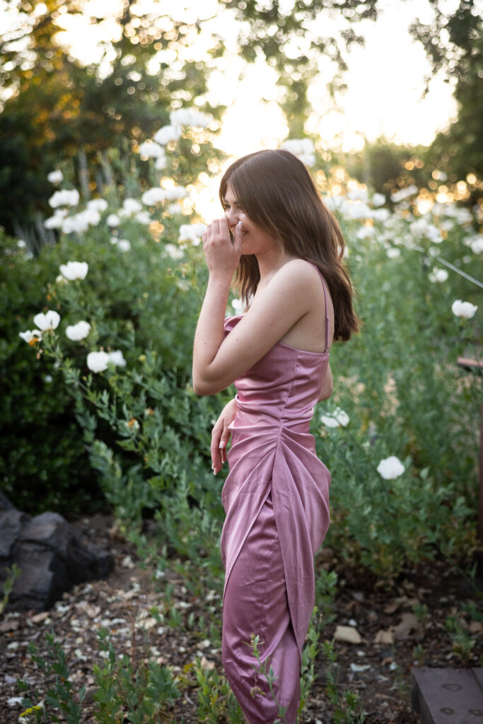 girl laughing wearing pink dress in garden