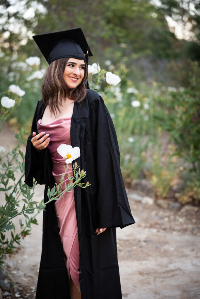 girl standing in garden with flowers for graduation
