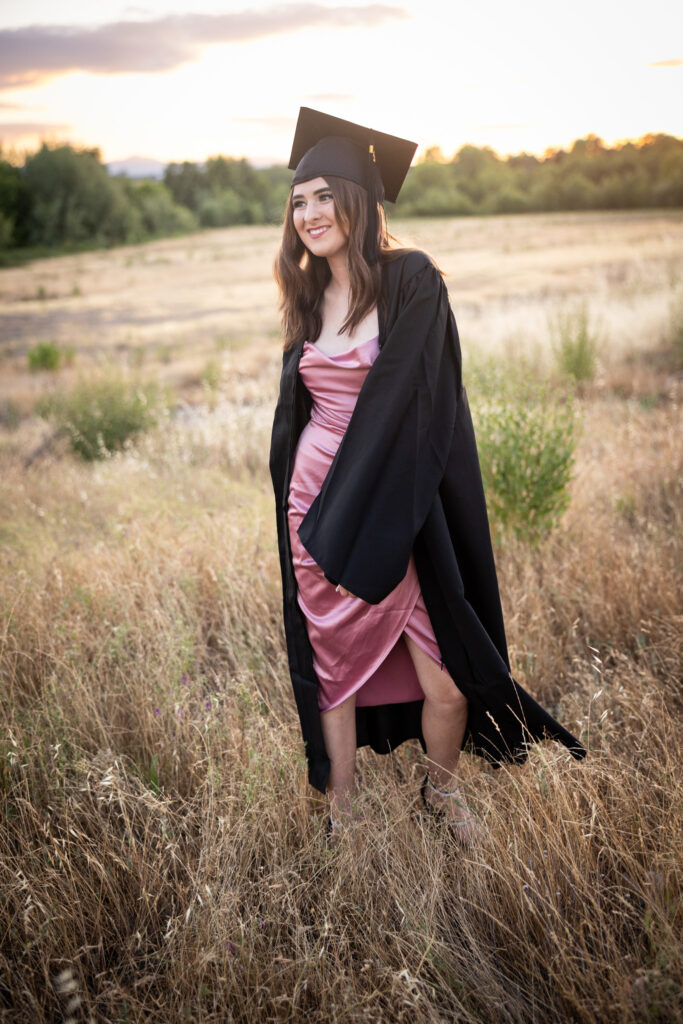girl standing gin field wearing cap and gown